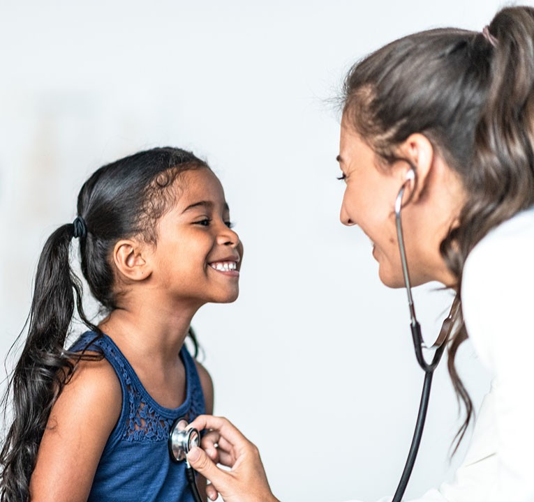 A young girl is being examined by a doctor with a stethoscope.