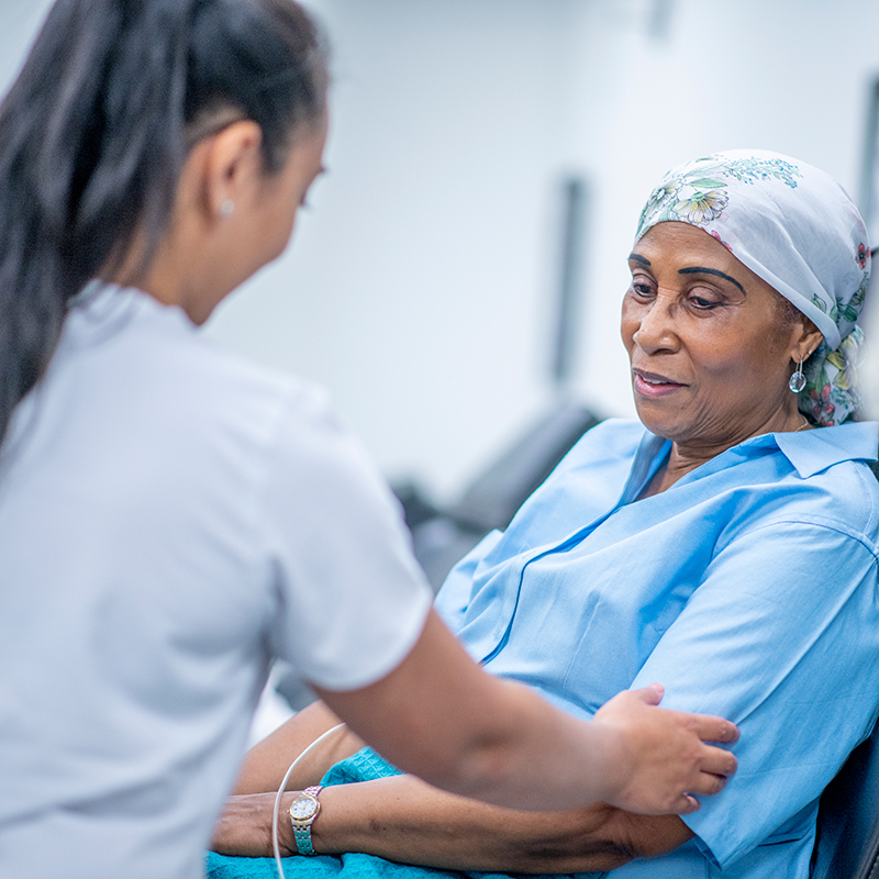 Nurse assists woman with immunotherapy treatment
